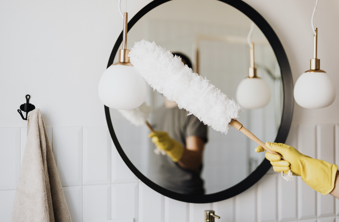 service worker in gloves removes dust from the mirror.