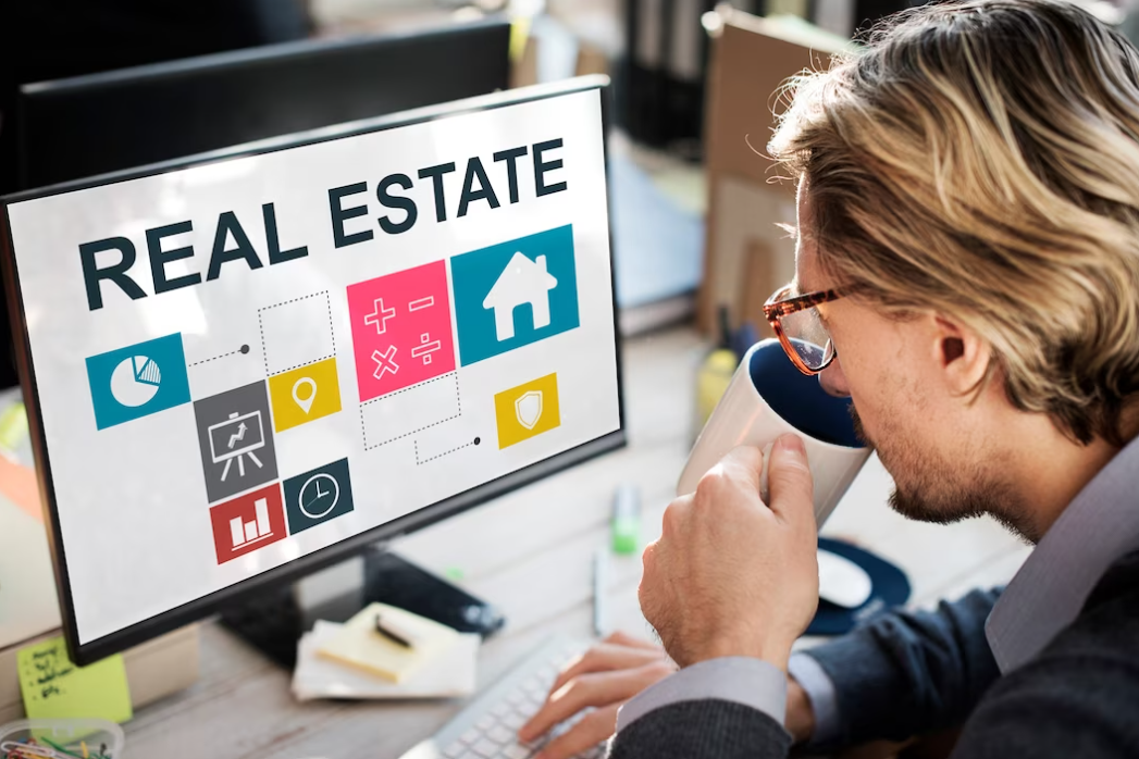 a real estate agent  working on the computer and drinking coffe, words real estate depicted on the screen