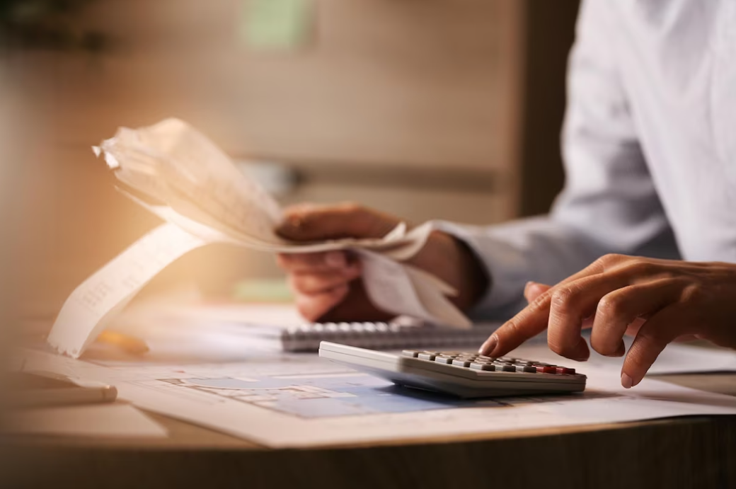 economist using calculator while going through bills and taxes in the office