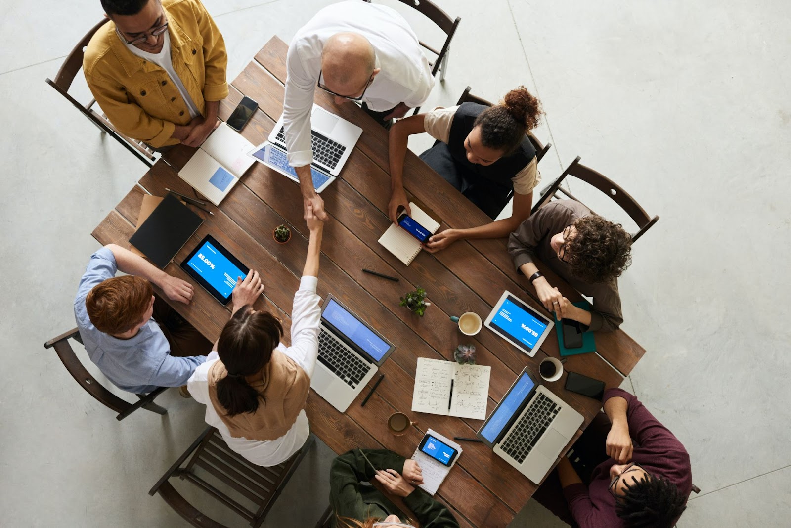 Several businessmen sitting at a table with laptops